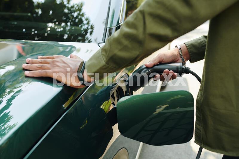 Owner taking plug out of socket after charging his EV