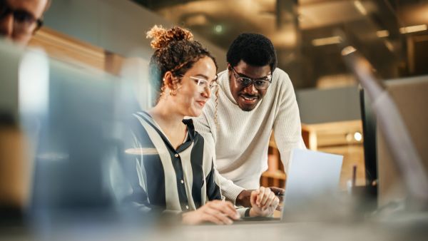 Colleagues using laptop to discuss work