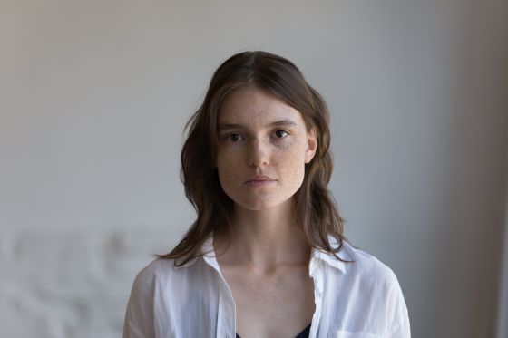 Serious pretty freckled young woman front head shot indoor portrait