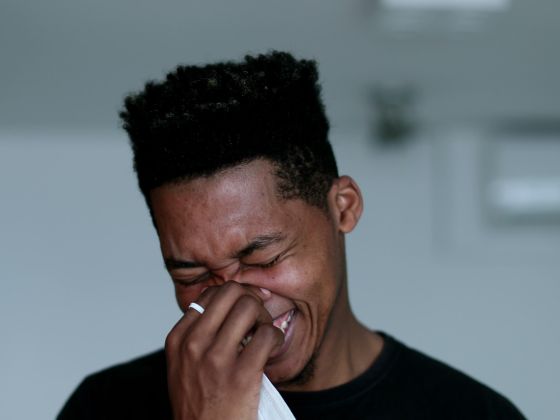 A young man laughs out loud spontaneously.