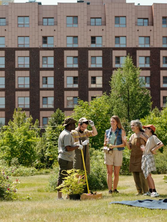 Group of diverse young adults and teenagers standing together in a garden.