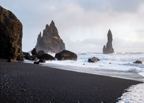 Black sand beach and sea rocks