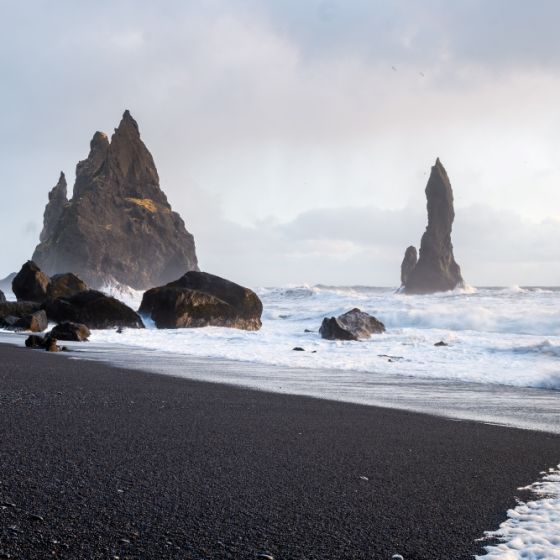 Black sand beach and sea rocks