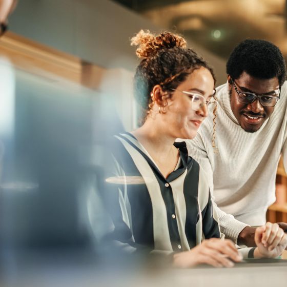 Colleagues using laptop to discuss work